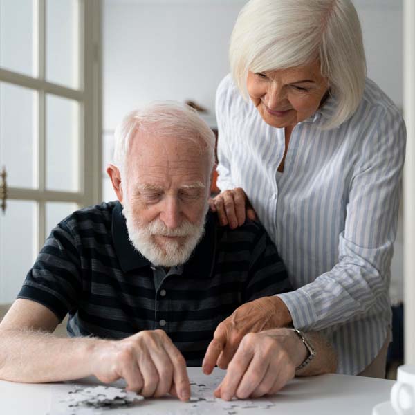 An older couple puts together a puzzle.