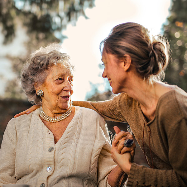 An older woman talking with a younger woman.